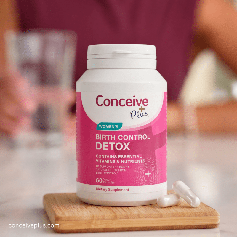 Conceive Plus birth control detox supplement bottle on a wooden cutting board with blurred background